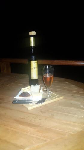 a bottle of wine and a glass on a table at Adega dos Terceira in Baía de Canas