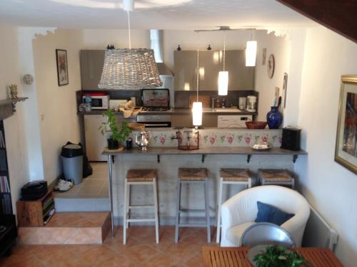 una cucina con bar e sgabelli in una stanza di Le Refuge a Peyriac-Minervois
