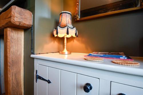una lampada seduta sopra un comò bianco di Daisy Cottage - Framlingham a Framlingham