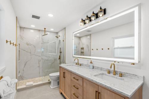 un bagno con un lavandino e un grande specchio di 502 Colony Street a Melbourne Beach