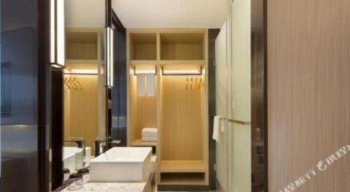 Echarm Hotel Changsha High-speed Railway Station في تشانغشا: حمام مع حوض ومرآة كبيرة