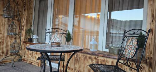 a table and two chairs in a room with a window at Amore Grande in Samokov