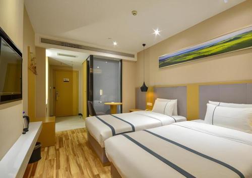 City Comfort Inn Jingzhou Hongxing Road Food Street في Shashi: غرفة فندقية بسريرين وتلفزيون