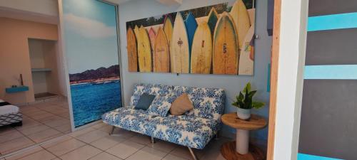 een kamer met een bank en surfplanken aan de muur bij Departamento tipo mediterraneo in Hermosillo