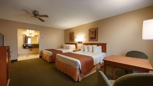 a hotel room with two beds and a table at SureStay Hotel by Best Western Tehachapi in Tehachapi