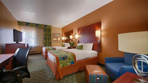 Best Western PLUS Fresno Inn في فريسنو: غرفة فندقية بسريرين واريكة