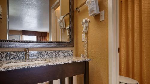 a bathroom with a sink and a mirror at SureStay Hotel by Best Western Floresville in Floresville