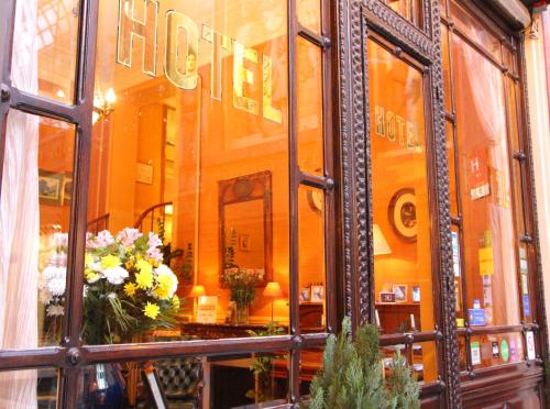 a reflection of a store window with flowers in it at Hôtel Chopin in Paris
