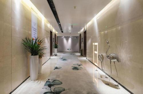 um corredor num edifício com plantas nas paredes em Shenzhen Apex Hotel (Technology Park Branch) em Shenzhen