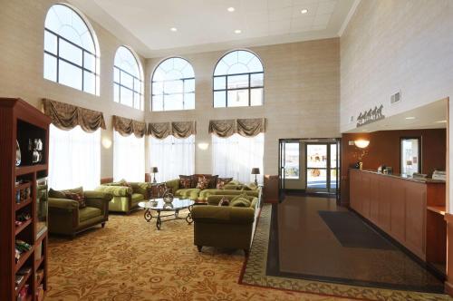 a large living room with green couches and windows at Best Western Plus Graham Inn in Graham