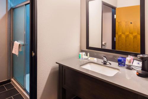 a bathroom with a sink and a mirror at Best Western Plus Regency Park in Walker