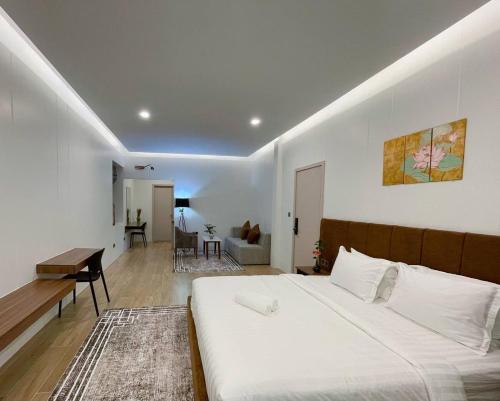 Un dormitorio con una cama grande y una sala de estar. en Private Villa by YUSETH Residence, en Phumĭ Ta Phŭl
