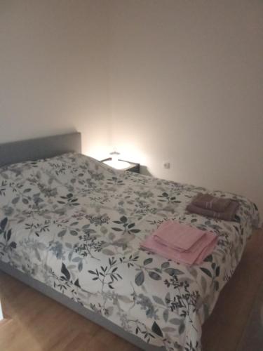 a bedroom with a bed with a floral bedspread at Apartmani Janićijević 2 in Kragujevac