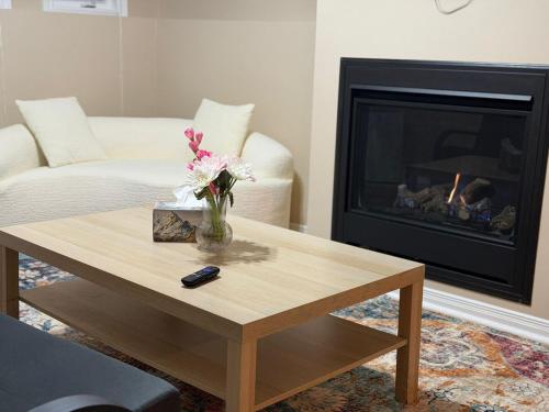 sala de estar con mesa de centro y chimenea en Cozy Private Basement Apartment in Fort Erie, en Fort Erie