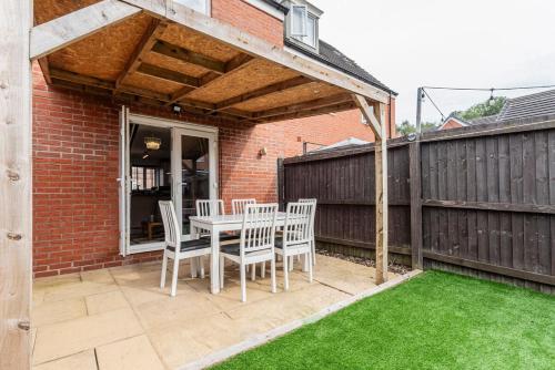 a patio with a table and chairs and a fence at Entire 2-bed house in Stoke-on-trent in Stoke on Trent