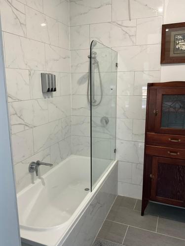 a bathroom with a tub and a glass shower at Fortuna views farm stay in Jumbuk