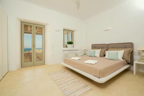 a bedroom with a large bed in a white room at Villa Ftelia Boheme in Elia
