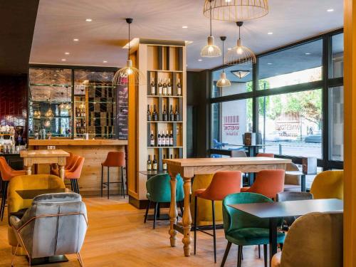 un bar con mesas y sillas coloridas en un restaurante en Mercure Budapest Korona, en Budapest