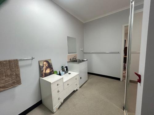 a white bathroom with a sink and a mirror at Bemm River Bungalows - Bellbird Abode - Bungalow 1 in Bemm River