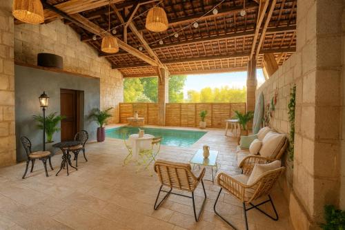 een patio met een zwembad en stoelen en een tafel bij Villa De Alexiano in Alixan
