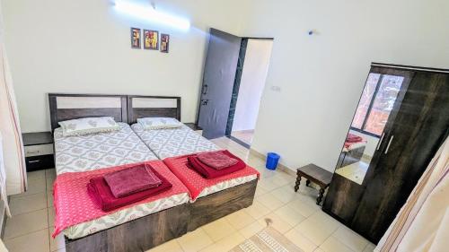 a bedroom with a bed with red pillows on it at Redstone Hills, Diveagar in Diveagar