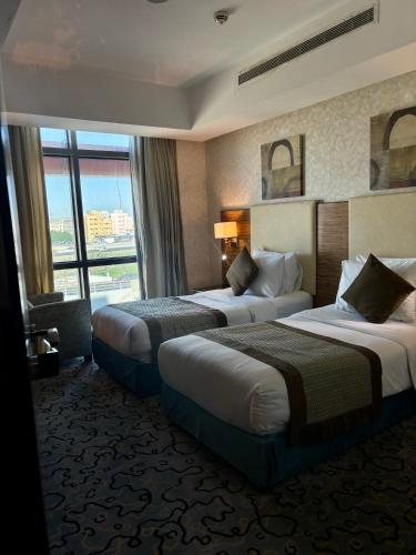 a hotel room with two beds and a window at فندق الشهباء جده Al Shahba Jeddah in Jeddah