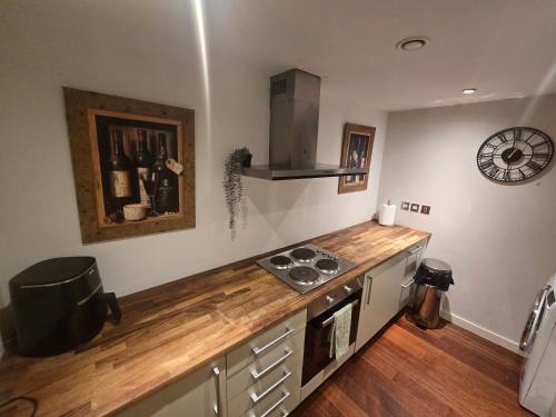 a kitchen with a counter with a stove and a clock at Ventro Apartments LIVERPOOL in Liverpool