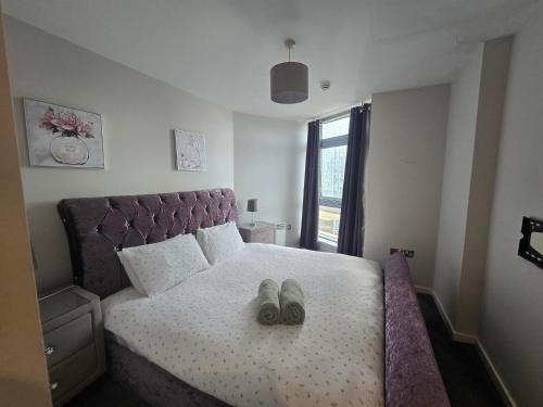 een slaapkamer met een bed met een paar schoenen erop bij Ventro Apartments LIVERPOOL in Liverpool