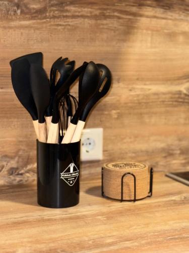 a black container filled with utensils on a table at Apartment Almtal Liebe in Viechtwang