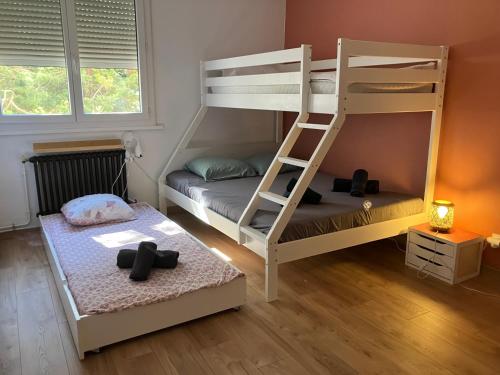 Deux lits superposés dans une chambre avec deux croix noires au sol dans l'établissement grand appartement Sete, à Sète