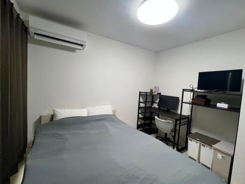 una camera da letto con un letto grande e una TV di Apartment Hotel in Katsushika City a Tokyo