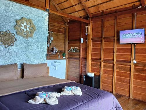 Casablanca Bira Resort في Tabutule: غرفة نوم عليها سرير وحذائين