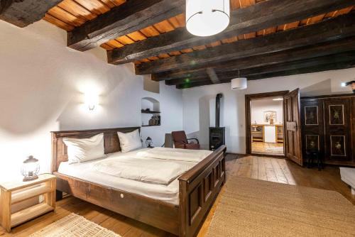een slaapkamer met een groot bed in een kamer met houten plafonds bij Veseud11 in Veseud-Agnita