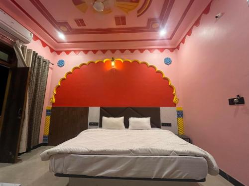 een slaapkamer met een bed met een boog erboven bij Hotel Simran Desert View Haveli in Pushkar