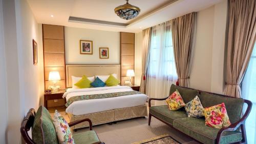 Viluveli Holiday Retreat في Hanimaadhoo: غرفة فندق بها سرير وأريكة