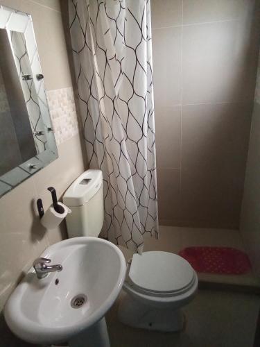 a bathroom with a white toilet and a sink at Mon soleil in Luanda