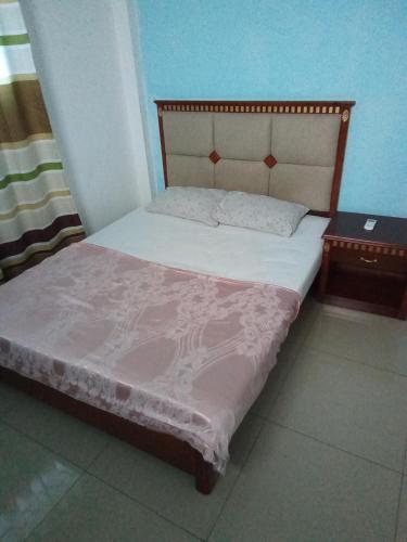 a bedroom with a bed and two night stands at Mon soleil in Luanda