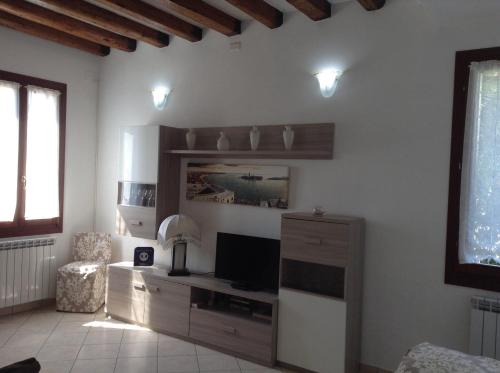 a living room with a tv and a cabinet with a television at Appartamento Paleocapa in Marghera