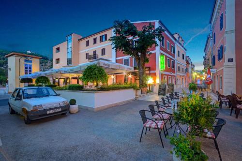 a car parked on a street with chairs and tables at Hotel Skradinski Buk in Skradin