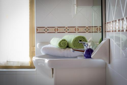 bagno con lavandino, asciugamani e specchio di Casa Vacanze Il Girasole ad Agropoli