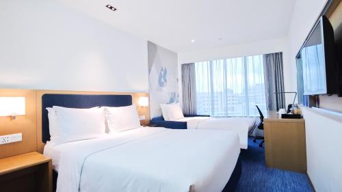 a hotel room with two beds and a large window at Holiday Inn Express Macau City Centre by IHG in Macau