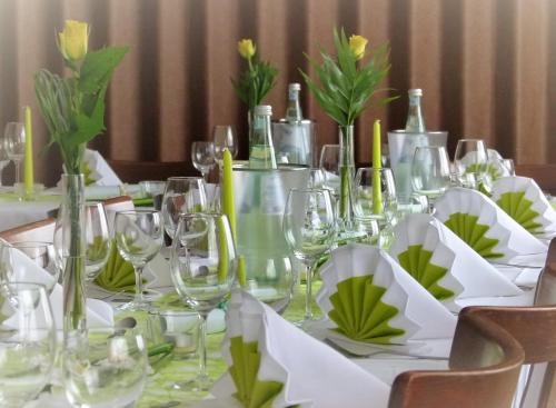 einen Tisch mit Weingläsern und Blumen darauf in der Unterkunft Landgasthof & Hotel "Merje" in Kreuztal