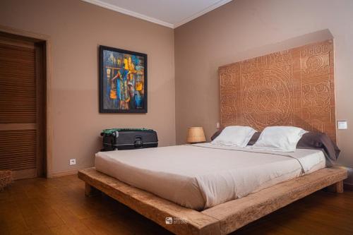 a bedroom with a large bed and a painting on the wall at Cocoa Beach Lodge sur Île Nosy Komba in Nosy Komba