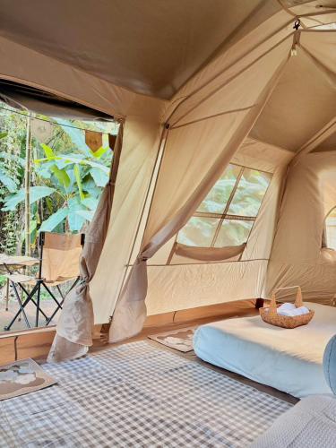a room with a tent with a bed in it at PimSook Homestay Riverside ที่พักแม่แตง
