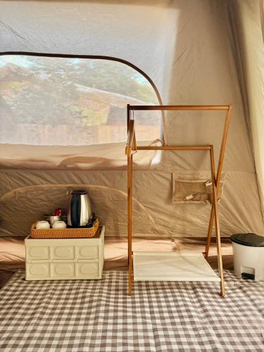 a tent with a bed and a table in it at PimSook Homestay Riverside ที่พักแม่แตง