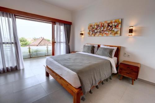 a bedroom with a large bed and a large window at Casa Serena Cemagi in Canggu