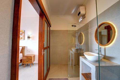 een badkamer met een wastafel en een spiegel bij Casa Serena Cemagi in Canggu