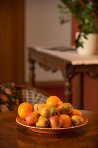 a plate of fruit on a wooden table at Hotel Schlössli Garni - Free Parking in Ipsach