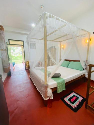 a bedroom with a bed with a canopy at Romaclan Villa in Midigama East