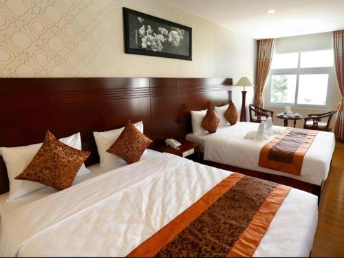 Giường trong phòng chung tại New Palace Bac Lieu Hotel